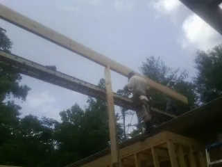 Carpenter setting a ridge beam over a new addition frame — Ice Dam Removal by Roofing Brothers in Hitchcock