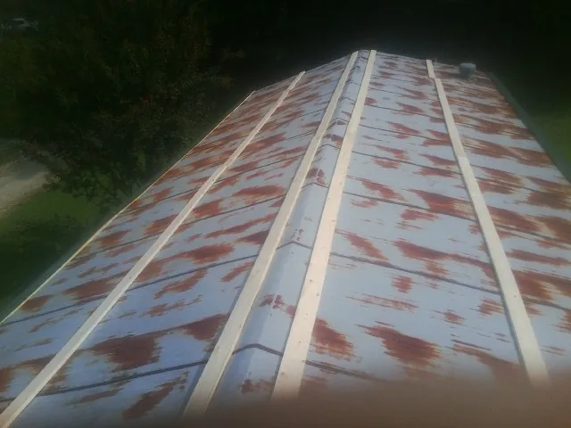 Rusted metal roof panels with new wood purlins before replacement — Storm Damage Roof Repair in Hitchcock by Roofing Brothers