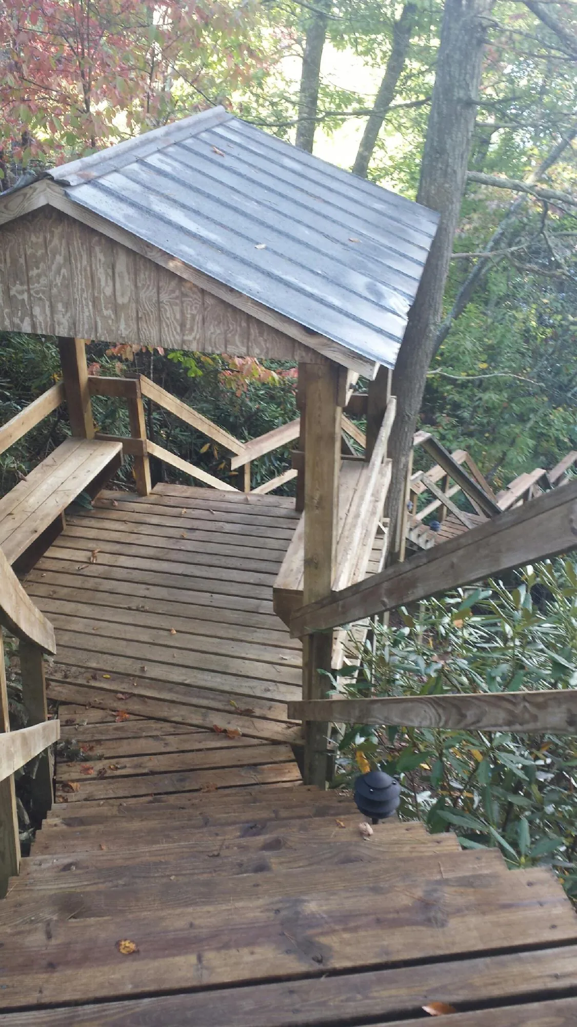 Metal roofed shelter over wooden steps on a wooded walkway — Skylight Repair & Installation work by our crew in Hitchcock